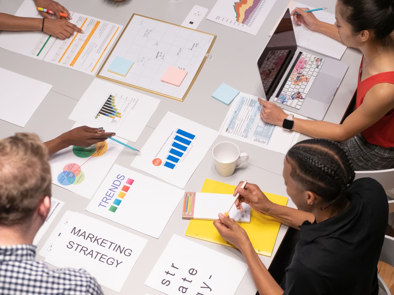 home-hero Overhead shot of diverse team analyzing marketing strategies with charts and graphs.